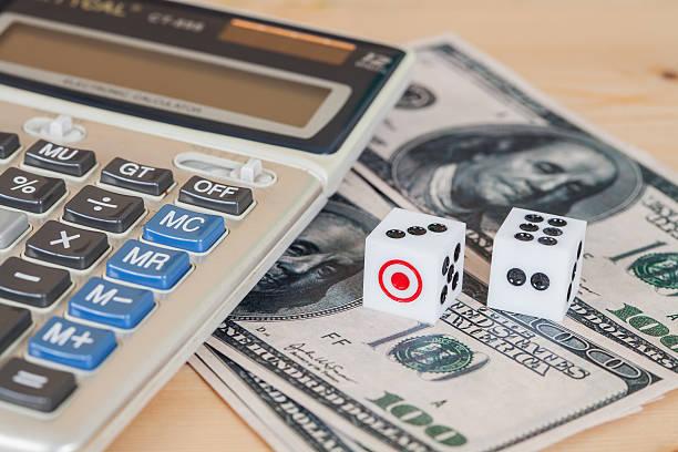 Two dices on wood table with US dollar and calculator Two dices on wood table with US dollar and calculator  paying off debt faster stock pictures, royalty-free photos & images